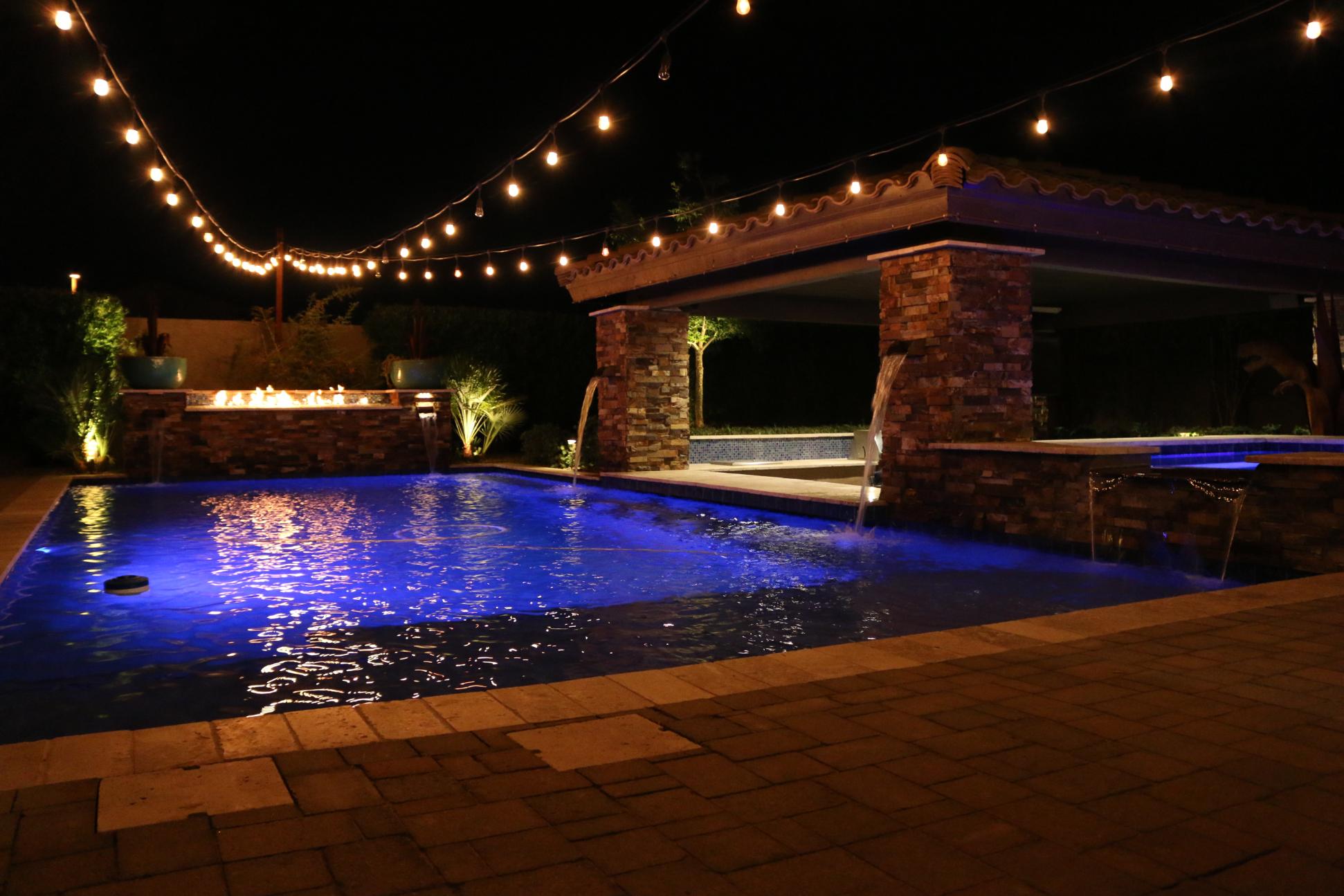 Custom pool with waterfall feature and surrounding landscape design